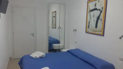 a bedroom with a blue bed and a mirror at Guest House San Pietro in Rome