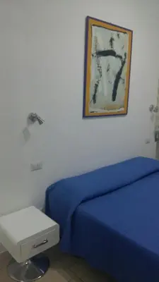 a bedroom with a blue bed and a picture on the wall at Guest House San Pietro in Rome