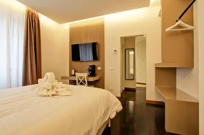 a bedroom with a white bed and a desk at SirtHouse in Rome