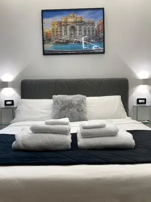 a bedroom with a bed with towels on it at Roma Tourist Rentals in Rome