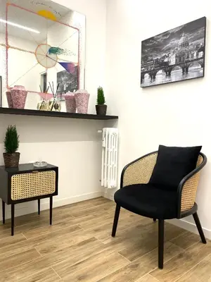 a chair and a side table in a room at Roma Tourist Rentals in Rome