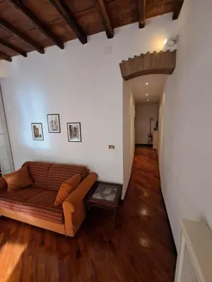 a living room with a couch and wooden floors at Home Piazza Dell'Orologio in Rome