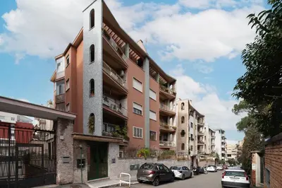 a building with a tower on the side of a street at CS Vatican Metro Apartment in Rome