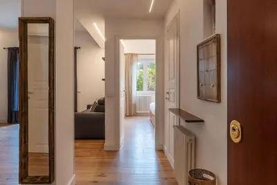 a hallway with a mirror and a living room at CS Vatican Metro Apartment in Rome
