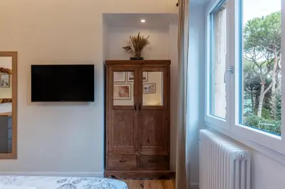 a room with a tv and a dresser and a window at CS Vatican Metro Apartment in Rome