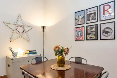 a dining room with a table with a vase of flowers at Delizioso appartamento a Roma in posizione strategica in Rome