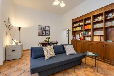 a living room with a blue couch and a book shelf at Delizioso appartamento a Roma in posizione strategica in Rome