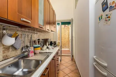 a kitchen with a sink and a refrigerator at Delizioso appartamento a Roma in posizione strategica in Rome