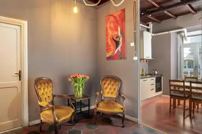 a dining room with two chairs and a table with a vase of flowers at Dimora Florea - in the heart of Campo de' Fiori in Rome