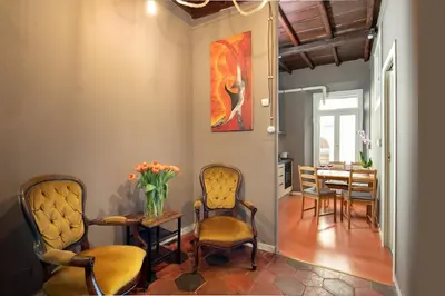 a dining room with chairs and a table with a vase of flowers at Dimora Florea - in the heart of Campo de' Fiori in Rome