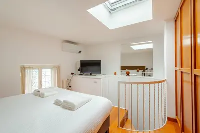 a white bedroom with a bed with towels on it at Cottage San Giovanni in Rome