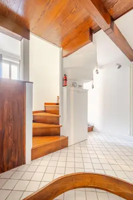 a kitchen with a wooden ceiling and stairs at Cottage San Giovanni in Rome