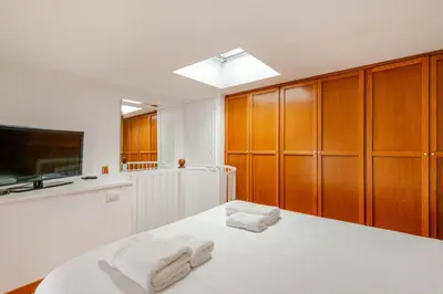 a bedroom with wooden cabinets and a bed with two towels at Cottage San Giovanni in Rome