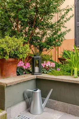 a metal tea kettle sitting on a ledge with plants at Cottage San Giovanni in Rome