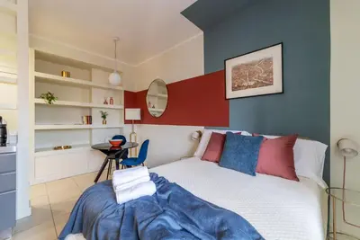 a bedroom with a white bed and a red accent wall at GuestHost - Aurea Domus Comfort suite in centro a Roma in Rome