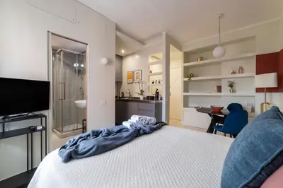 a bedroom with a bed and a television and a desk at GuestHost - Aurea Domus Comfort suite in centro a Roma in Rome