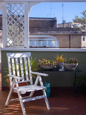 a rocking chair sitting on a balcony with plants at Luxury Penthouse Parioli in Rome