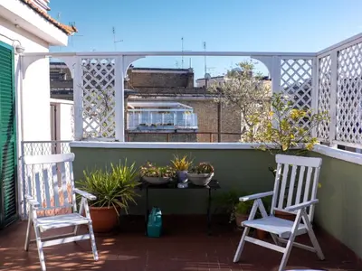 two chairs sitting on a balcony with plants at Luxury Penthouse Parioli in Rome