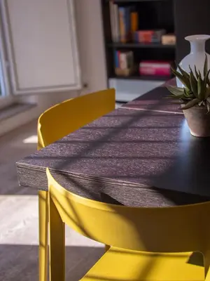 a dining room table with two yellow chairs and a black table at Luxury Penthouse Parioli in Rome