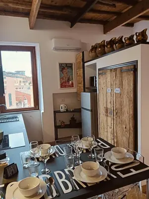 a kitchen with a table with plates and wine glasses at luxury suites Trastevere in Rome