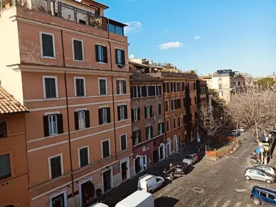 an apartment building with cars parked on a street at luxury suites Trastevere in Rome