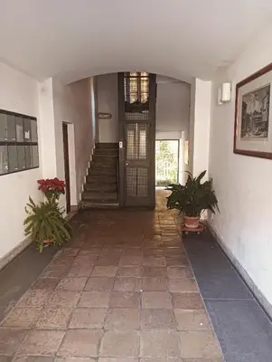 a hallway with a door and two potted plants at luxury suites Trastevere in Rome