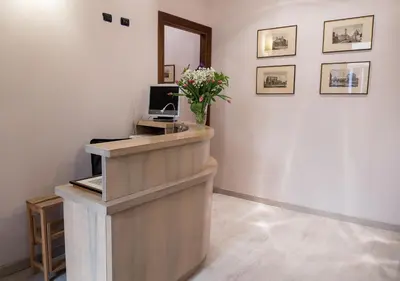 a reception desk with a vase of flowers in a room at Campo Marzio Charming in Rome