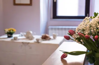 a vase of flowers on a table with a sink at Campo Marzio Charming in Rome