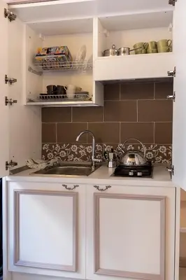 a kitchen with white cabinets and a sink at Campo Marzio Charming in Rome