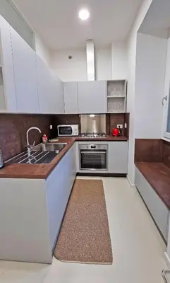 a kitchen with white cabinets and a sink at Il Cortile del 900 in Rome