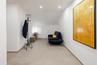 a living room with a chair and a painting on the wall at Design Apt Moderno Pzz del Popolo - Parking in Rome