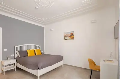 a white bedroom with a bed with yellow pillows at Design Apt Moderno Pzz del Popolo - Parking in Rome