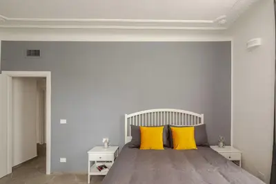 a bedroom with a large bed with yellow pillows at Design Apt Moderno Pzz del Popolo - Parking in Rome