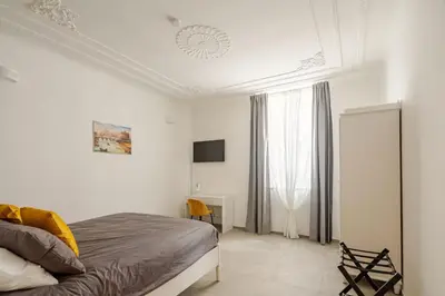 a white bedroom with a bed and a tv at Design Apt Moderno Pzz del Popolo - Parking in Rome