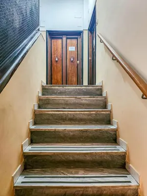 a set of stairs leading to a wooden door at Mami Apartment in Rome