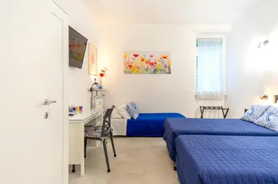a bedroom with two beds and a desk and a table at Mami Apartment in Rome
