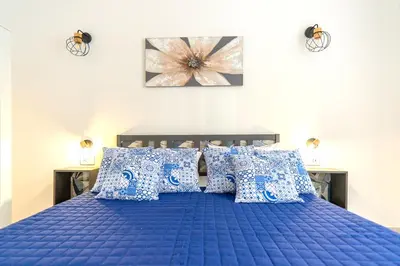 a bedroom with a blue bed with blue pillows at Mami Apartment in Rome