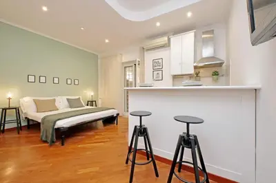 a bedroom with a bed and two bar stools at La Dolce Vita - Vatican Studio with Large Terrace in Rome