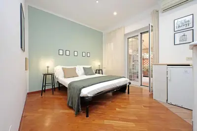 a bedroom with a bed in a room with a kitchen at La Dolce Vita - Vatican Studio with Large Terrace in Rome