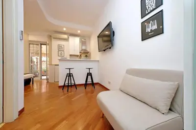a living room with a couch and a kitchen at La Dolce Vita - Vatican Studio with Large Terrace in Rome