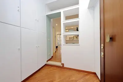a hallway with white walls and a wooden door at La Dolce Vita - Vatican Studio with Large Terrace in Rome