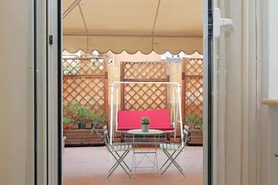a patio with a pink chair and a table at La Dolce Vita - Vatican Studio with Large Terrace in Rome
