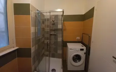 a bathroom with a shower and a washing machine at Il regno dei colori in Rome