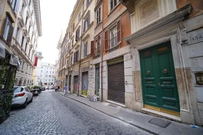 an alley with a green door on a building at Juan&Elisa Trevi by BuddyRent in Rome