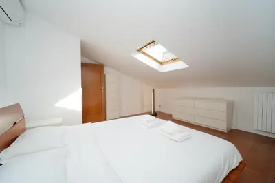 a bedroom with a white bed with a skylight at Juan&Elisa Trevi by BuddyRent in Rome