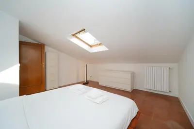 a bedroom with a white bed and a skylight at Juan&Elisa Trevi by BuddyRent in Rome