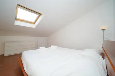 a white bed in a room with a window at Juan&Elisa Trevi by BuddyRent in Rome
