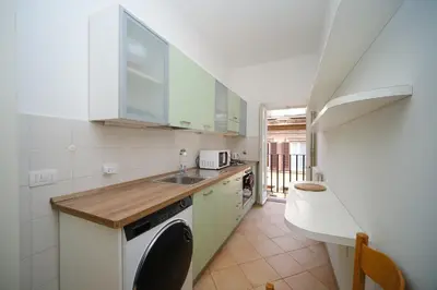 a kitchen with a sink and a washing machine at Juan&Elisa Trevi by BuddyRent in Rome