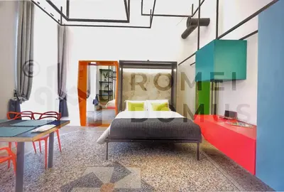 a bedroom with a bed and a table in it at GALAXY By ROMEI in Rome