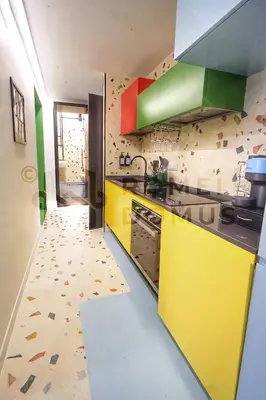 a kitchen with yellow and green cabinets and a tile floor at GALAXY By ROMEI in Rome